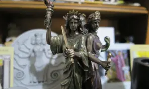 Figurka Hekate z pochodnią i mieczem, symbolizująca jej moc nad magią i przejściami.
