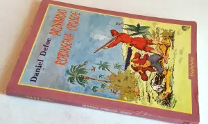 Okładka "Przygód Robinsona Crusoe" Daniela Defoe. Na ilustracji widzimy postacie na tropikalnej wyspie, gdzie jeden z bohaterów, niczym piętaszek, walczy o przetrwanie.