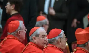 Kardynałowie w czerwonych szatach, uosobienie cnót kardynalnych, w skupieniu słuchają.