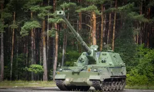 Zielona armata samobieżna, niczym współczesny rzymski bóg wojny, stoi na tle sosnowego lasu, gotowa do akcji.