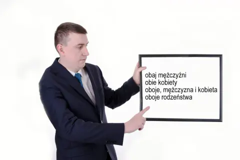 Mężczyzna w garniturze wskazuje na tablicę z napisami: "obaj mężczyźni", "obie kobiety", "oboje, mężczyzna i kobieta", "oboje rodzeństwa".