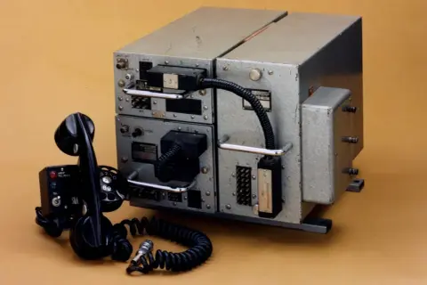 Pierwszy telefon komórkowy, masywny sprzęt z lat 60. XX wieku, z charakterystyczną słuchawką i tarczą numerową.