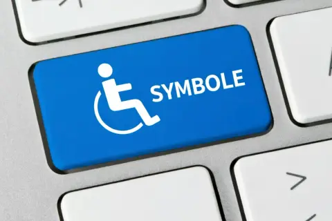 Niebieski klawisz z symbolem osoby na wózku inwalidzkim i napisem "SYMBOLE". Co oznacza symbol n 12f?