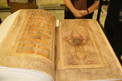 Otwarta księga z ilustracjami: po lewej geometryczny wzór, po prawej demon. Uniwersalizm średniowiecznych manuskryptów.