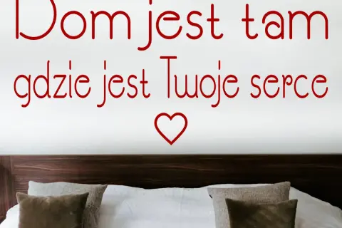 Dom jest tam, gdzie jest Twoje serce. Romantyczny cytat na ścianie nad łóżkiem z poduszkami.