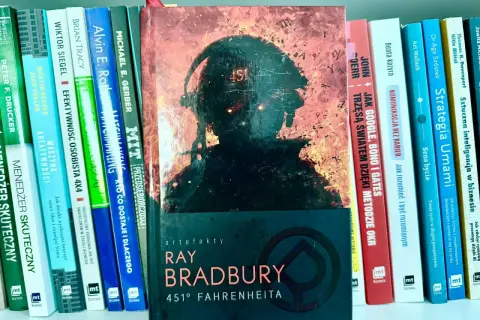 Okładka "451° Fahrenheita" Ray'a Bradbury'ego obok książek o biznesie, odzwierciedlająca pragmatyzm w wyborze lektur.