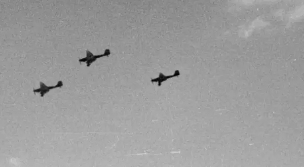 Trzy samoloty Luftwaffe w formacji lecące na tle nieba.
