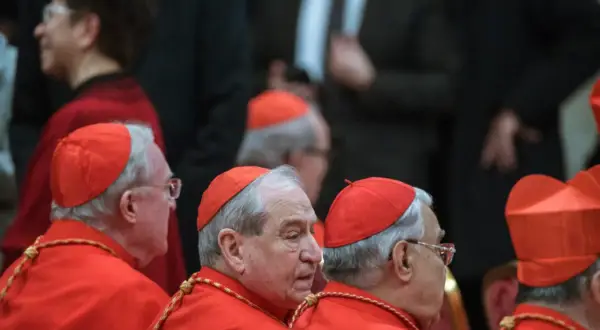Kardynałowie w czerwonych szatach, uosobienie cnót kardynalnych, w skupieniu słuchają.