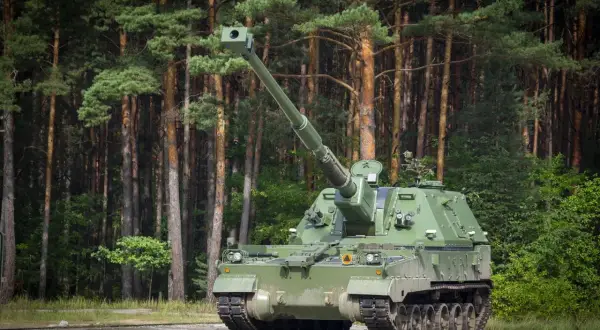 Zielona armata samobieżna, niczym współczesny rzymski bóg wojny, stoi na tle sosnowego lasu, gotowa do akcji.
