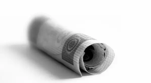 Zrolowany banknot polski, symbol zmian i stabilności waluty po denominacji w Polsce.