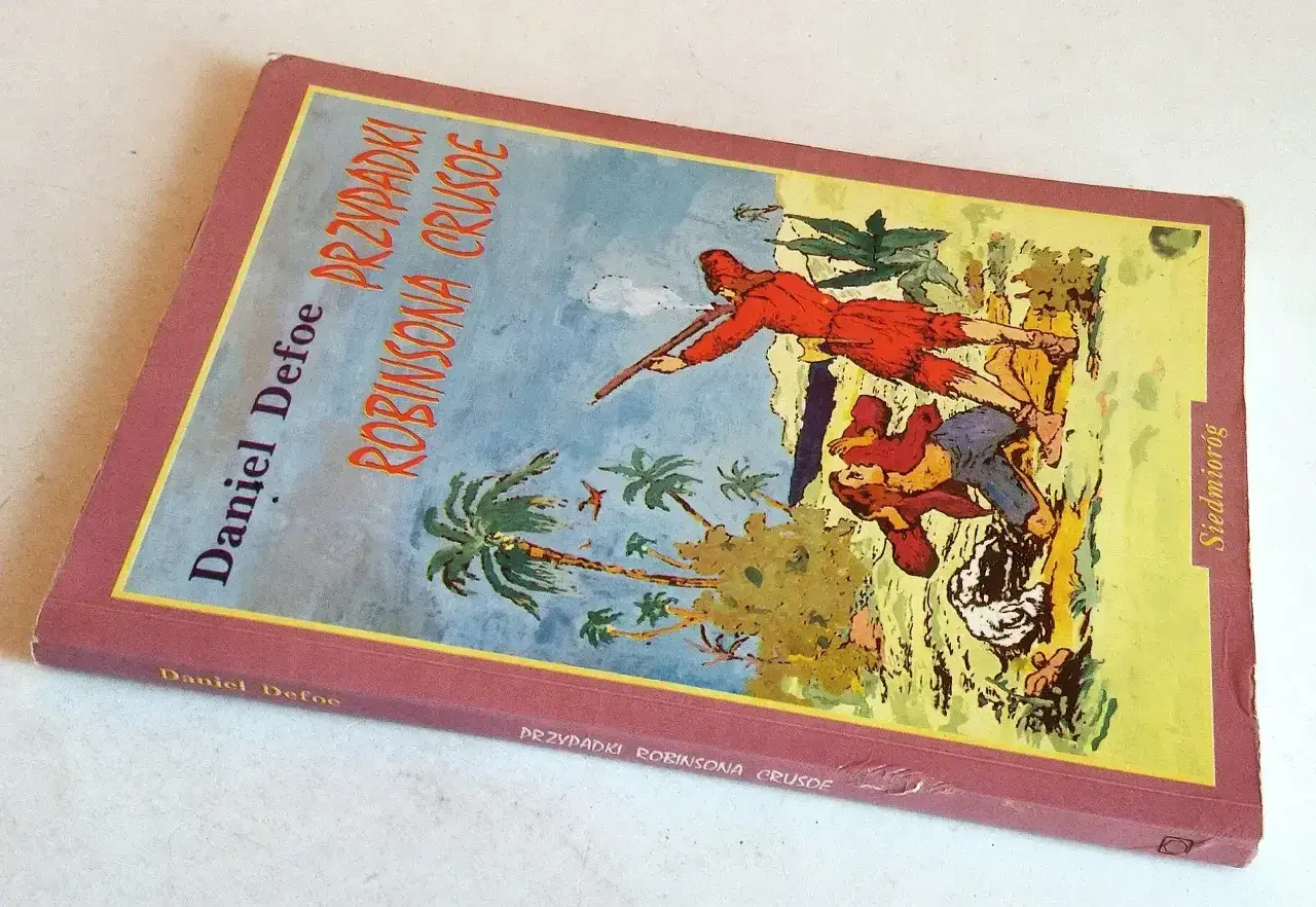 Okładka "Przygód Robinsona Crusoe" Daniela Defoe. Na ilustracji widzimy postacie na tropikalnej wyspie, gdzie jeden z bohaterów, niczym piętaszek, walczy o przetrwanie.