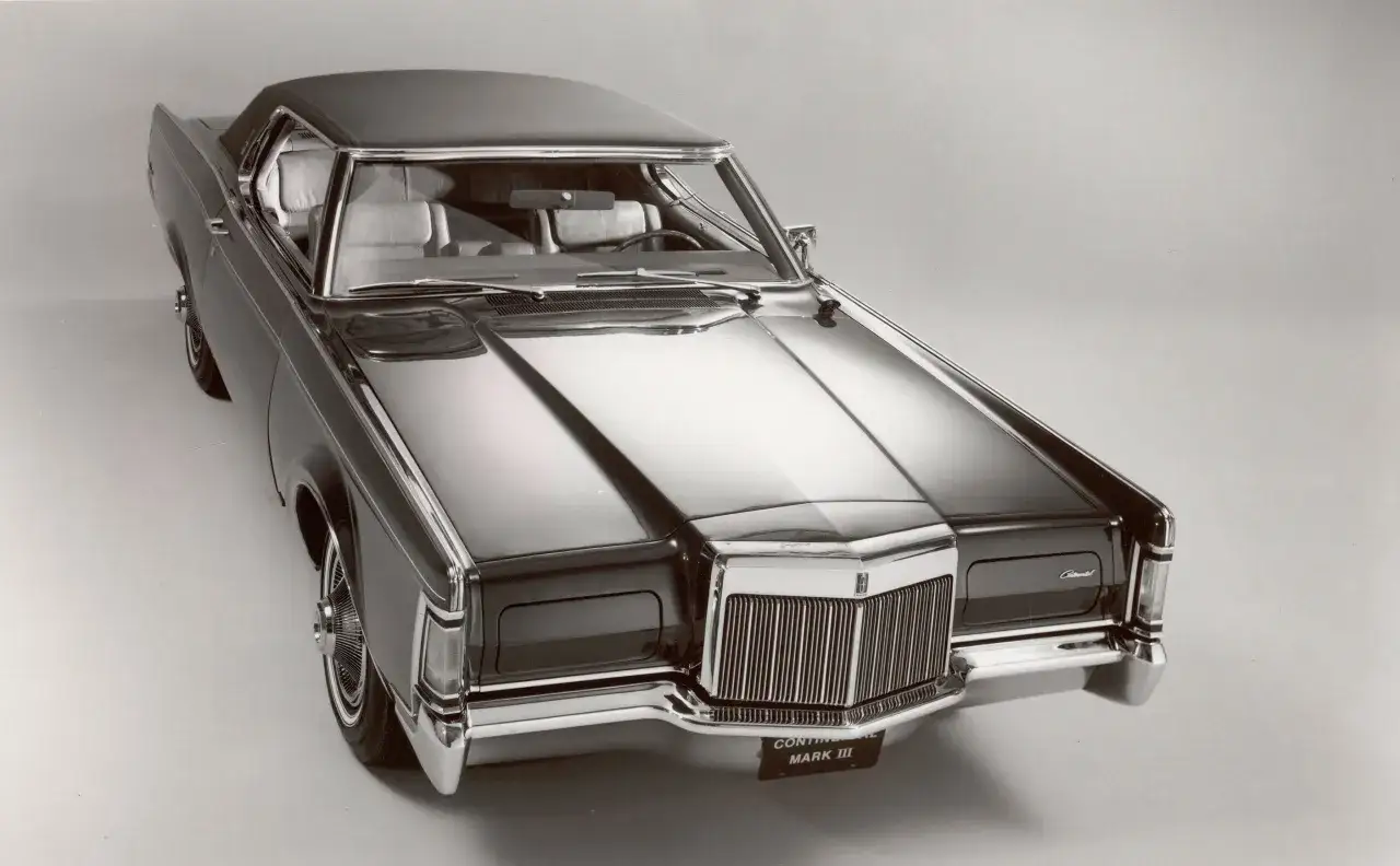Elegancki, czarny Lincoln Continental Mark III z lat 60. błyszczy na tle.