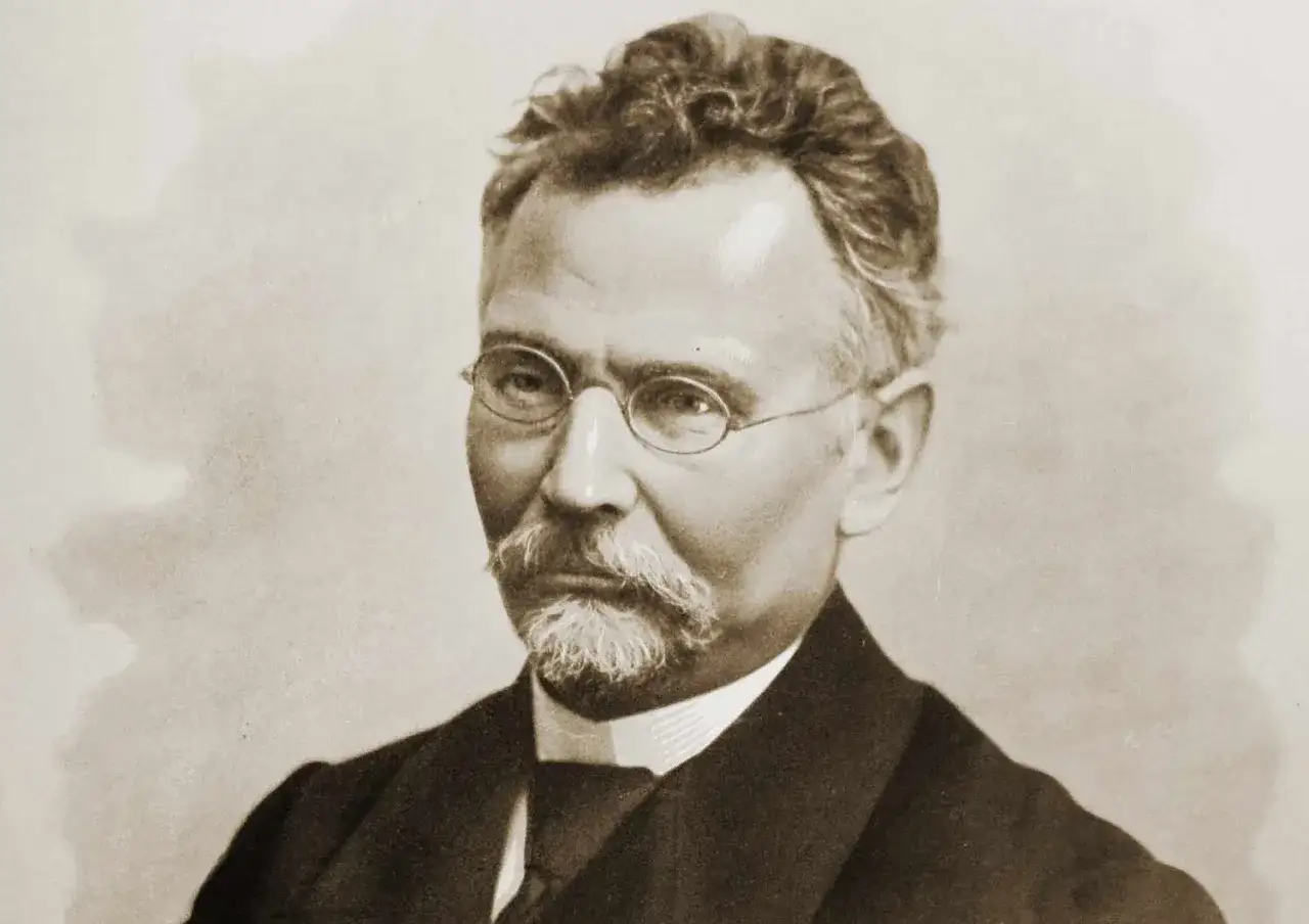 Portret mężczyzny w okularach, z wąsami i brodą. Wygląda jak duch, jakby był lalką z dawnych czasów.