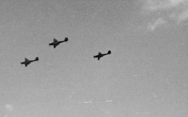 Trzy samoloty Luftwaffe w formacji lecące na tle nieba.